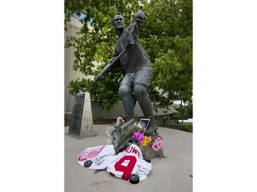 Flowers, jerseys, pucks and pictures lay next to the skates of the statue of Gordie Howe at SaskTel Centre in Saskatoon, June 10, 2016.