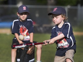 Boys and girls aged 4 to 7 years Dragon Braves baseball team take batting practice before a game against Royal Rockets on North Park Wilson School ball diamonds in league play, June 13, 2016.