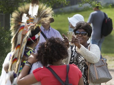 Visitors have photos taken with indigenous dancers after the grand entry in the amphitheatre at Wanuskewin Heritage Park at the opening of the Aboriginal Day Celebration, June 21, 2016.