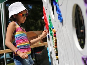 Simratia Hamre Wyka participates in a collaborative art project using bottle caps at Art in the Park in 2016