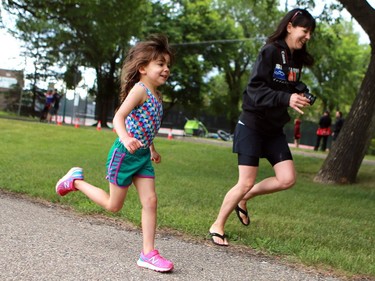 Sophie Banek runs to the finish line with her mom in the Kids of Steel Triathlon at Riversdale Pool and Victoria Park in Saskatoon on June 19, 2016.