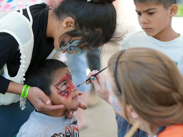 Ghofran Khalyan helps her little brother get his face painted during the PotashCorp Children's Festival at Kiwanis Park in Saskatoon, June 5, 2016.