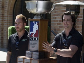 SASKATOON,SK--JULY 21/2015--Edmonton Rush players Ryan Dilks, left, and Chris Corbeil bring in the championship trophy after owner  Bruce Urban announced the move of the National Lacrosse League Champions to Saskatoon, Tuesday, July 21, 2015 in a news conference in Saskatoon. (Greg Pender/The StarPhoenix)