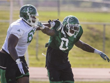 Defensive lineman #0 Jonathan Newsome (R) duels offensive lineman Kennedy Estelle during Roughrider spring camp in Saskatoon, June 1, 2016.