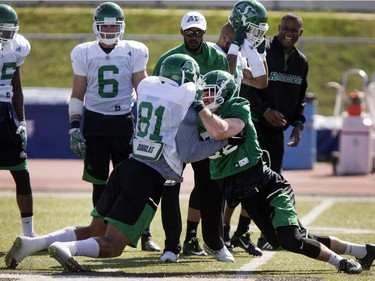 Wide receiver Marcus Davis (L) and defensive back Dan West mix it up in drills during Roughrider spring camp in Saskatoon, June 1, 2016.