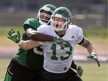 Greg Jones, linebacker, is draped all over Levi Steinhauer during Rider training camp at Griffiths Stadium in Saskatoon, Friday, June 03, 2016.