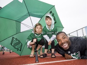 Shamawd Chambers of the Saskatchewan Roughriders mugs for the camera with young fans Emilie and Sophia Hvidston at Rider training camp at Griffiths Stadium in Saskatoon, Friday, June 03, 2016. Sophia is a blood recipient and, with Chambers, helped launch Canadian Blood Services Bleed Green program for season seven.