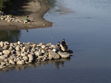 People enjoy fishing from the rocky shoreline of the South Saskatchewan River near the South Circle Drive Bridge, June 6, 2016.