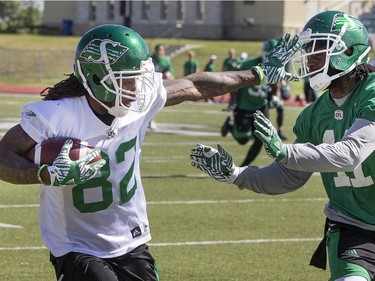 Wide receiver Naaman Roosevelt puts a hand in defensive back Ed Gainey's face during Roughrider training camp at Griffiths Stadium, June 15, 2016.