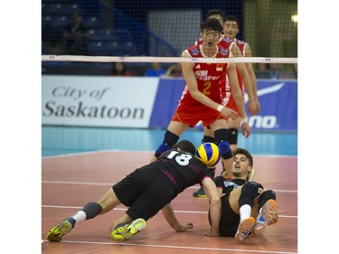 Longhai Chen of China (top) watches as Portugal players #18 Andre Reis Lopes and Tiago Da Silva Violas fail to dig up a ball during FIVB World Volleyball League action at Sasktel Centre in Saskatoon, June 24, 2016.