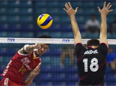 QingYao Dai of China (L) hits against the block of Portugal player #18 Andre Reis Lopes during FIVB World Volleyball League action at Sasktel Centre in Saskatoon, June 24, 2016.