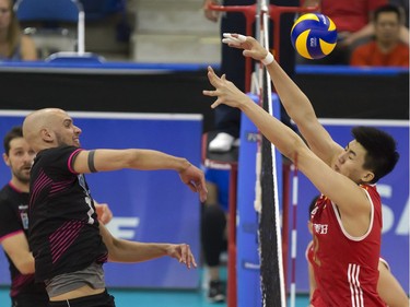 Shuhan Rao of China (R) attempts to block the spike of Portugal player Marcel Keller Gil during FIVB World Volleyball League action at Sasktel Centre in Saskatoon, June 24, 2016.