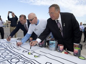 Federated Co-operatives Ltd. Associate Vice President Ron Healy, Saskatoon Co-op general manager Grant Wicks and Mayor Don Atchison paint a mural that will be delivered to Fort McMurray along with thousands of cans of paint.