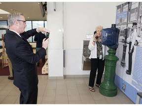 Michael Hesse of the Denver Police Museum takes a photo of  Pat Nading-Amman beside an historical police call box at the Saskatoon police station during a tour for police historians, Tuesday, June 28, 2016.