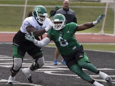 Offensive lineman Xavier Fulton (L) and defensive lineman Shawn Lemon square off in one-on-one drills during Roughrider camp at Griffiths Stadium, May 31, 2016.