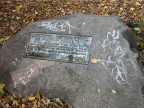 SASKATOON,SK-- October 16/2014-- Nola Stein, project manager for the Meewasin Valley Authority, shows off areas of the trail system which are in need of repair,  Thursday, October 16, 2014. For Phil Tank story. A graffiti-covered marker noting the first ten km's of the trail which is in Cosmopolitan Park. (GREG PENDER/STAR PHOENIX)