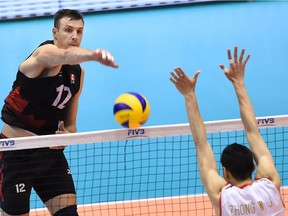 Gavin Schmitt (L) of Canada spikes the ball over Zhong Weijun (R) of China during the men's volleyball world final qualification for the Rio de Janeiro Olympics 2016 in Tokyo on June 5, 2016.