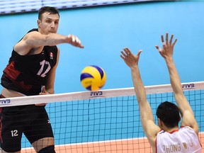 Gavin Schmitt (L) of Canada spikes the ball over Zhong Weijun (R) of China during the men's volleyball world final qualification for the Rio de Janeiro Olympics 2016 in Tokyo on June 5, 2016. /