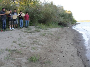 A portion of a group of more than 30 people who gathered on the banks of the South Saskatchewan River to participate in a water song ceremony on Wednesday night. The group is also in the early stages of organizing a water drive for communities with limited water supplies due to a Husky Energy Inc. oil spill that leaked more than 200,000 litres of oil into the North Saskatchewan River. (Morgan Modjeski/The Saskatoon StarPhoenix)