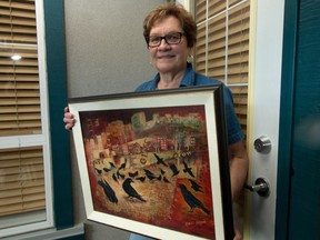 Artist Natalie Kurzuk poses in her Calgary home with her painting Urban Landscape with Crows that went missing in Saskatoon two years ago and was returned to her in Calgary on Monday July 4, 2016.