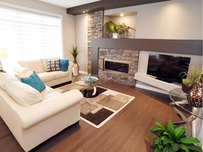 Boychuk Construction opted for a contemporary theme when designing and building its new show home at 335 Flynn Manor in Rosewood. The focal point of the living room is a unique feature wall, featuring a modern painted mantel, decorative art niche and angled TV ledge. Recessed lighting is located in the bulkhead along the ceiling. The decorative stonework surrounding the linear gas fireplace is an eye-catching blend of grey, brown and copper tones. (Photo: Boychuk Construction)