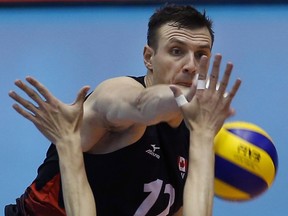 Gavin Schmitt of Canada spikes against China during their Men's Volleyball World Olympic qualification tournament match in Tokyo, Sunday, June 5, 2016.