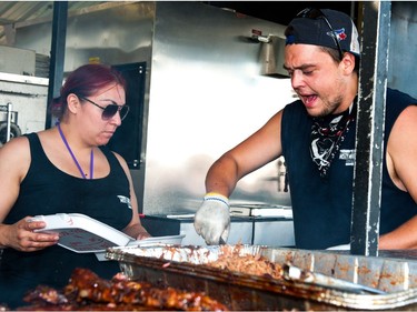 Jake Robinson, right, and Raylene Lumberjack of Misty Mountain BBQ were on the grind, slinging sauced up ribs during Saskatoon Ribfest at Diefenbaker Park in Saskatoon on July 29, 2016.