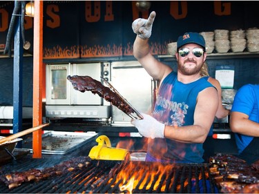 Jeff Rimmer of Boss Hog's BBQ mans the grill at his company's booth during Saskatoon Ribfest at Diefenbaker Park in Saskatoon on July 29, 2016.