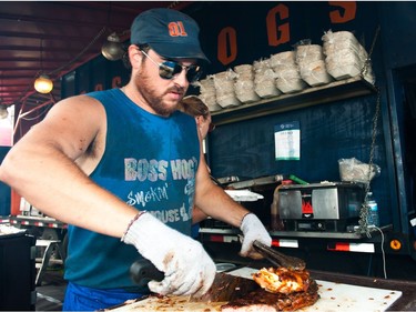 Jeff Rimmer of Boss Hog's BBQ serves up huge slabs of meat during Saskatoon Ribfest at Diefenbaker Park in Saskatoon on July 29, 2016.