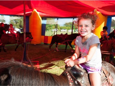 Nova Hawkins, 3, of Saskatoon enjoys her pony ride during Saskatoon Ribfest at Diefenbaker Park in Saskatoon on July 29, 2016.