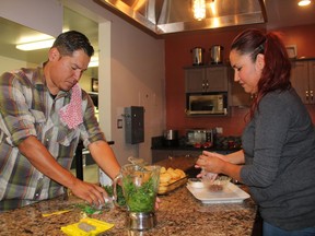 Rich Francis, left Chef and owner of Seventh Fire Indigenous Cuisine and Rachel Eyahpaise, owner of Bannock Express, work together in the kitchen at the Saskatoon Farmers Market ahead of a pop-up restaurant event that took place earlier this week. The two said preparing First Nations cuisine is about more than the dish, as they're reclaiming a genre of cuisine that was lost to colonization.