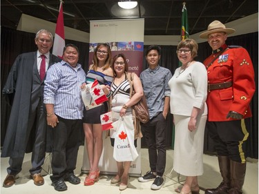 The Mordles family from the Philippines have their photo taken after becoming Canadians at a Citizenship ceremony with Officer of the Order of Canada Arnolt Boldt (L), Saskatoon MP Sheri Benson and retired RCMP constable Ross Taylor in Saskatoon at the Western Development Museum on Canada Day, July 1, 2016.
