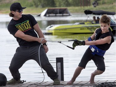 World water ski champion Ryan Dodd (L) works with Saskatoon's Cater Lucas on shore before venturing out to the water skiing jump ramp at his clinic in the city at the water ski club's pond, July 7, 2016.