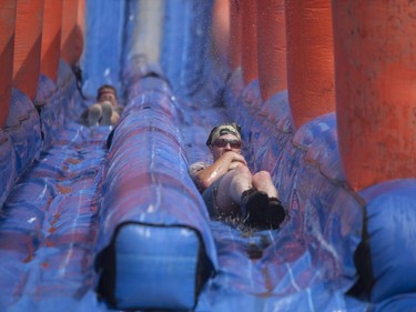 Competitors slide down an obstacle while attempting to complete the 5K Foam Fest run near Pike Lake on Saturday, July 2nd, 2016.