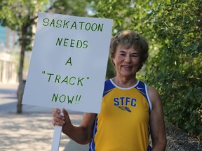 Master Athlete and former Olympian, Margaret Tosh holds up a sign outside of City Hall that reads 'Saskatoon needs a track now' on July 18, 2016. (Michelle Berg / The StarPhoenix)