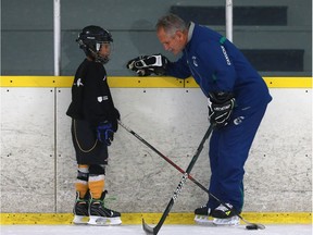 Vancouver Canucks coach Willie Desjardins gives Daryll Kkailther some tips at Schroh Arena in Saskatoon on July 18, 2016.