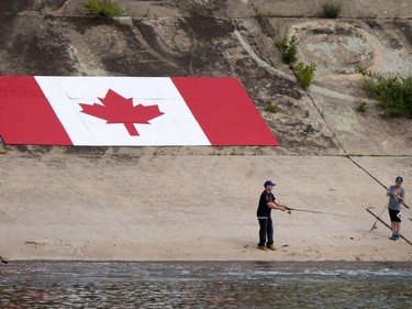 People fish from the weir apron with a huge Canada flag for a backdrop,, July 6, 2016.