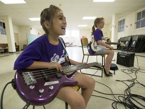 Ramona Oltra, left, and Faith Walker practise during Girls Rock Camp at Grace Westminster Park on Thursday.