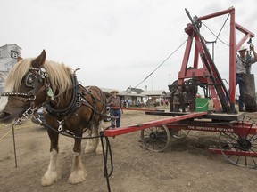 Doran Degenstein, with reins at left, and Brent Northey, working the drill, demonstrate a water drill rig at the Western Development Museum, on Friday, July 8, 2016.