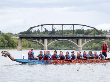 Competitors paddle their dragon boat to the starting line during FMG's Saskatoon Dragon Boat Festival along the South Saskatchewan river near Rotary Park in Saskatoon, July 23, 2016.