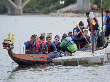 Competitors exit their dragon boat during FMG's Saskatoon Dragon Boat Festival along the South Saskatchewan river near Rotary Park in Saskatoon, July 23, 2016.