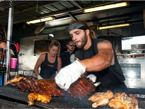 The crew of Gator BBQ's booth kept a close eye on the grill during Saskatoon Ribfest at Diefenbaker Park in Saskatoon on July 29, 2016.