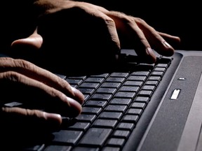 male hands on the keyboard,low key and high contrast,may suggest cyber cryme, hacking,spying