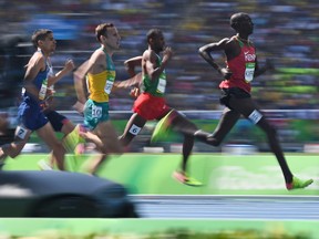 Kenya's Asbel Kiprop (R) competes in the Men's 1500m Round 1 during the athletics event at the Rio 2016 Olympic Games at the Olympic Stadium in Rio de Janeiro on August 16, 2016.   /