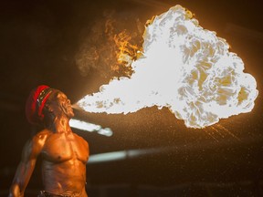 Prince Niah plays with fire in the Caribbean pavilion of Folkfest at Prairieland Park, Thursday, August 13, 2015.