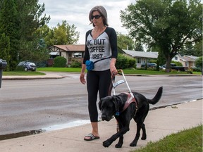 Bobbi Janzen takes her service dog for a walk during a cloudy afternoon in Saskatoon on July 29, 2016.