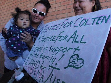 Michelle VanMeesen holds her friend's baby, nine-month-old Gladyssa Paskemin, beside a sign calling for justice for Colten Boushie outside of Saskatoon's provincial court on Thursday morning, August 18, 2016. Approximately 50 people attended the rally, which was one of several taking place across Saskatchewan.