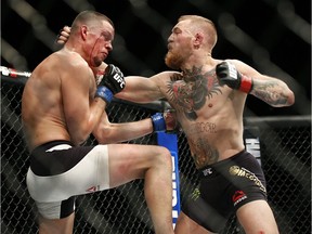 In this Saturday, March 5, 2016 file photo, Conor McGregor, right, trades punches with Nate Diaz during their UFC 196 welterweight mixed martial arts match in Las Vegas