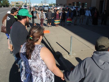 Participants at a Justice for Colten Boushie rally in Saskatoon join hands outside of Saskatoon's provincial courthouse on Thursday morning, August 18, 2016. Roughly 50 people attended the rally, which was one of several taking place across Saskatchewan as the man accused in Boushie's death, Gerald Stanley, appeared in court in North Battleford.