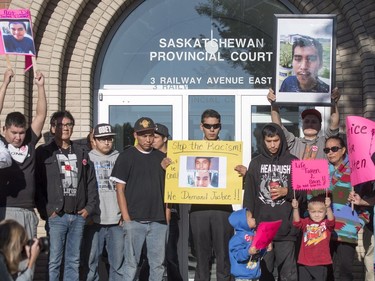 Family, friends and supporters for Colten Boushie hold signs during a rally outside of the Saskatchewan Provincial Court in North Battleford, August 18, 2016. People rally outside a Saskatchewan courthouse Thursday where a farmer accused of fatally shooting a First Nations man is to make an appearance.